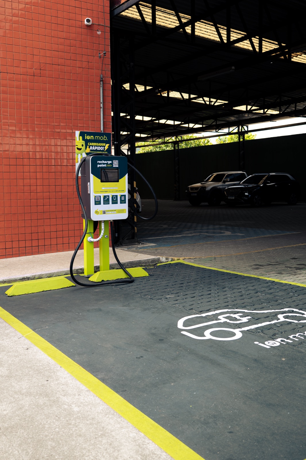 Estação de recarga ION instalada em estacionamento de varejo, com vaga sinalizada